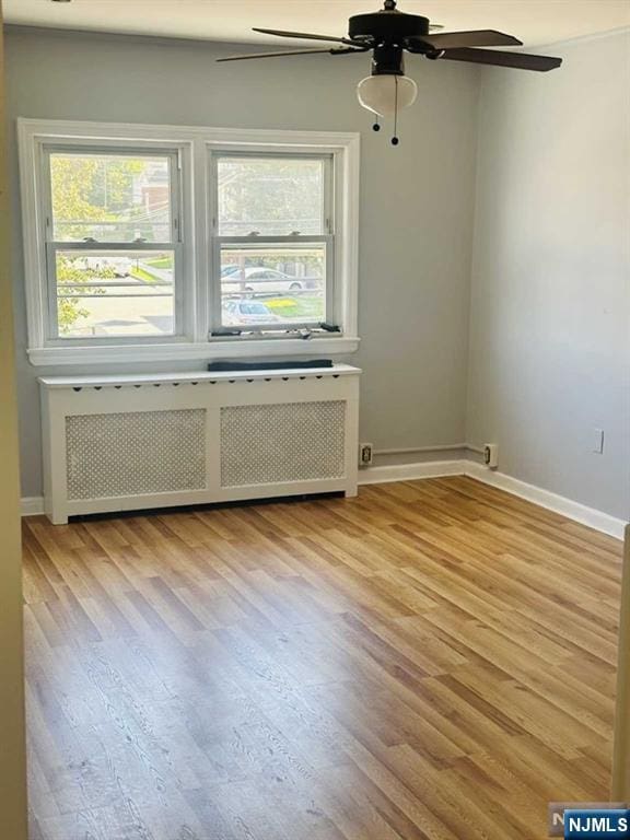 821 Roosevelt Ave, Secaucus, NJ 07094 - spare room with ceiling fan, radiator heating unit, and light hardwood / wood-style floors
