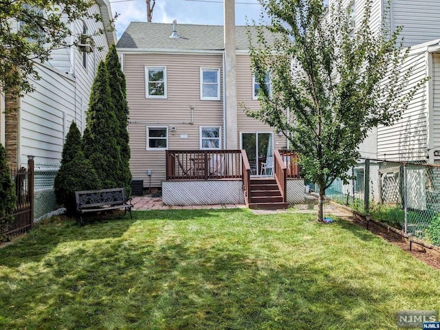 back of house with a deck and a lawn