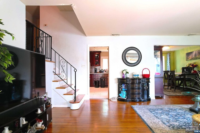 entrance foyer with hardwood / wood-style floors and lofted ceiling