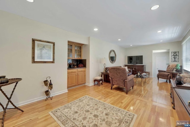 living room with light wood-type flooring and bar area