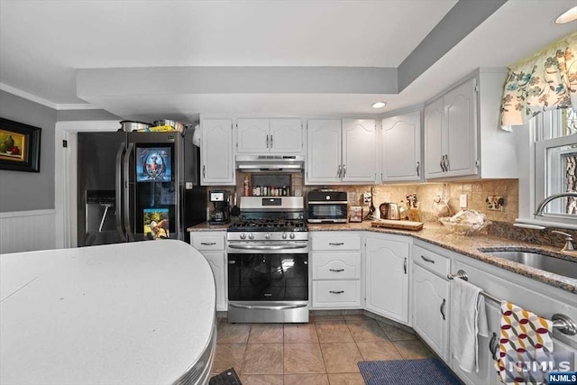 kitchen featuring gas range, black refrigerator with ice dispenser, sink, and white cabinets