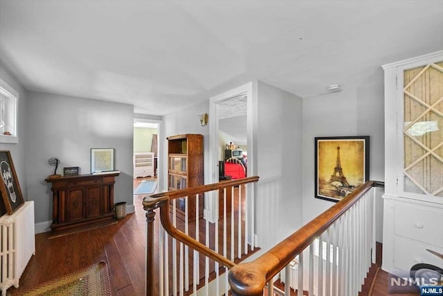 hall with dark wood-type flooring and radiator