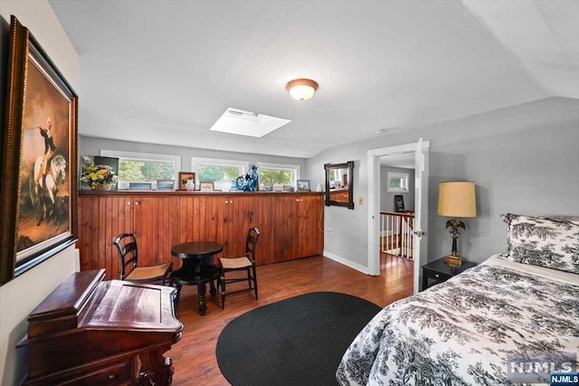 bedroom featuring hardwood / wood-style floors and vaulted ceiling with skylight