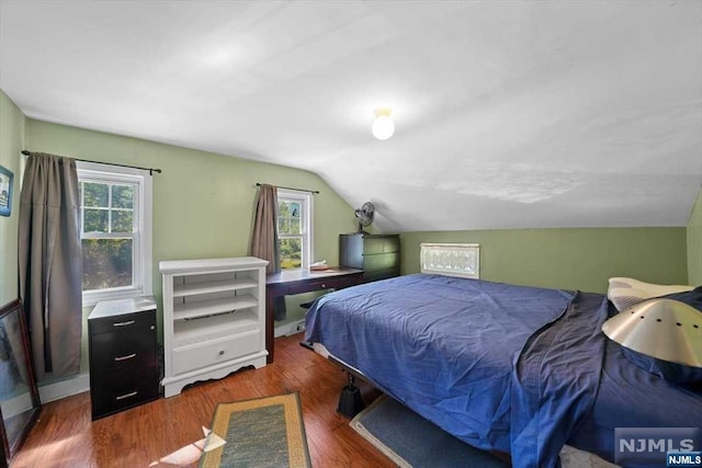 bedroom with dark wood-type flooring, multiple windows, and lofted ceiling