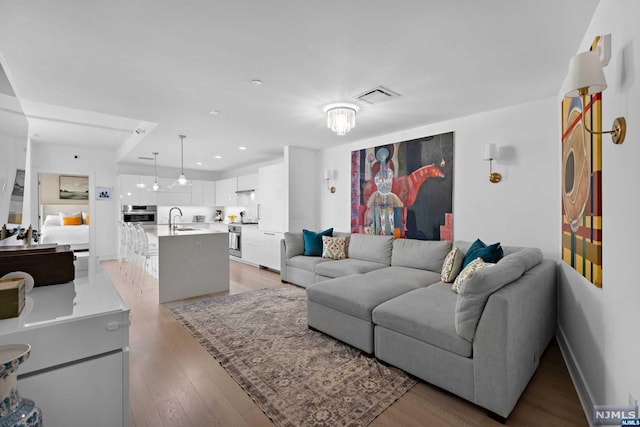 living room featuring light wood-type flooring and sink