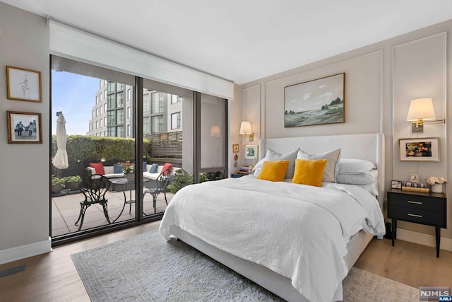 bedroom featuring access to exterior and hardwood / wood-style flooring