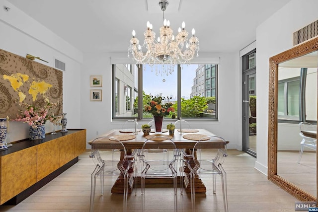 dining space with an inviting chandelier and light wood-type flooring