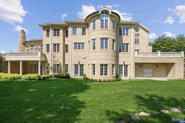 back of house featuring a lawn and french doors