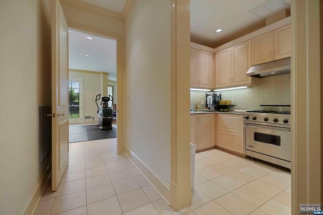 kitchen featuring light brown cabinets, crown molding, stainless steel range, tasteful backsplash, and light tile patterned flooring