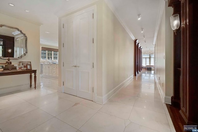 hall featuring light tile patterned floors and ornamental molding