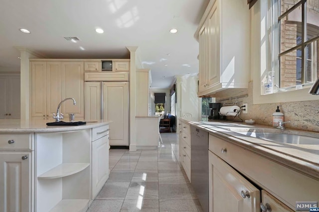 kitchen featuring cream cabinets, decorative backsplash, dishwasher, and sink