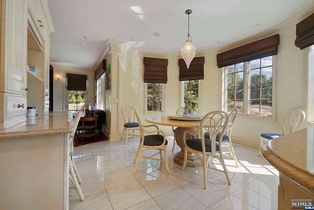 tiled dining room featuring crown molding