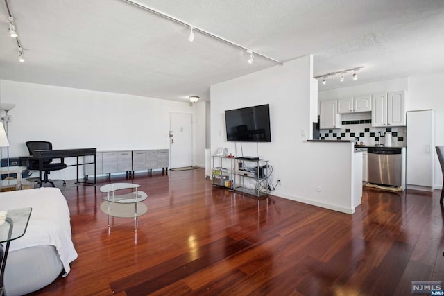 living room featuring a textured ceiling, dark hardwood / wood-style floors, and rail lighting