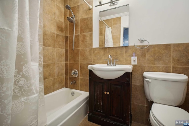 full bathroom featuring vanity, shower / bath combo, toilet, and tile walls