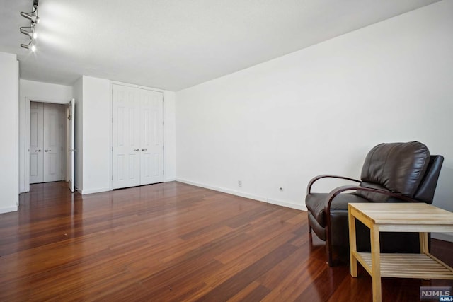 sitting room with dark hardwood / wood-style flooring and rail lighting