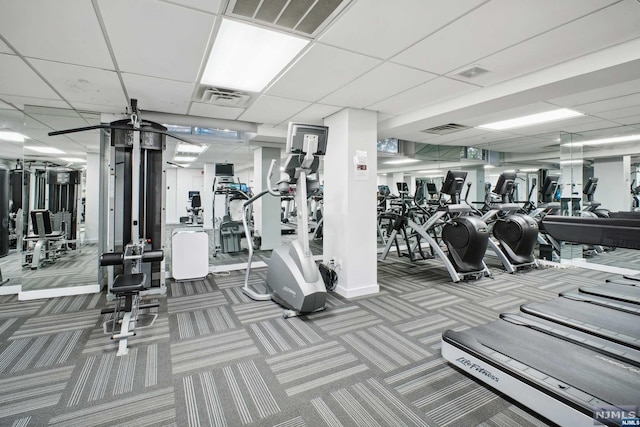 exercise room featuring carpet flooring and a paneled ceiling