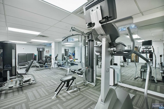 exercise room featuring a drop ceiling and light carpet