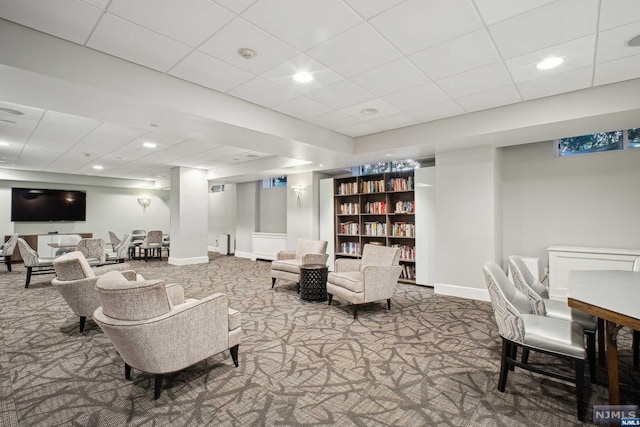 carpeted living room with a drop ceiling