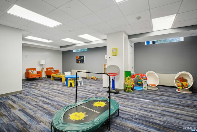 playroom with carpet flooring and a drop ceiling