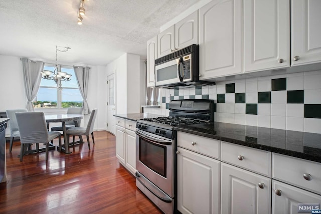 kitchen featuring white cabinetry, pendant lighting, a chandelier, and appliances with stainless steel finishes