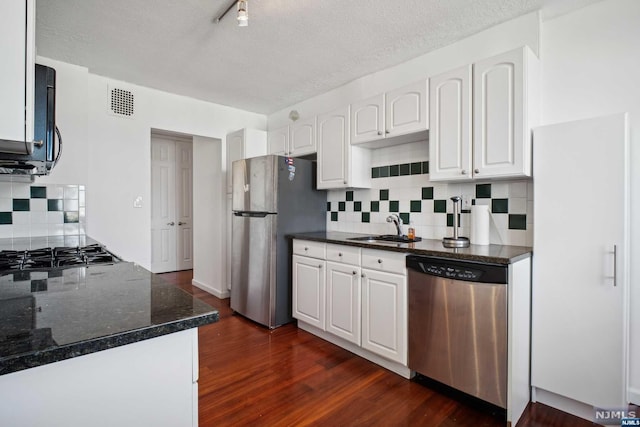 kitchen with stainless steel appliances, white cabinetry, dark wood-type flooring, and sink