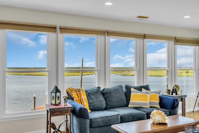 sunroom / solarium featuring a water view