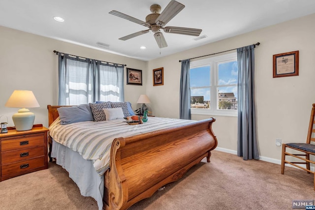 bedroom featuring multiple windows, light carpet, and ceiling fan