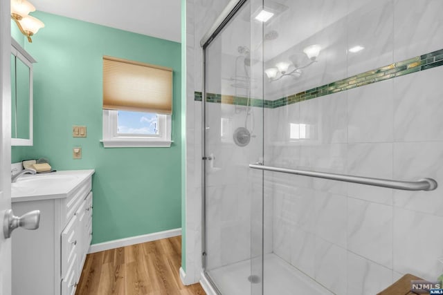 bathroom featuring vanity, a shower with shower door, and hardwood / wood-style flooring