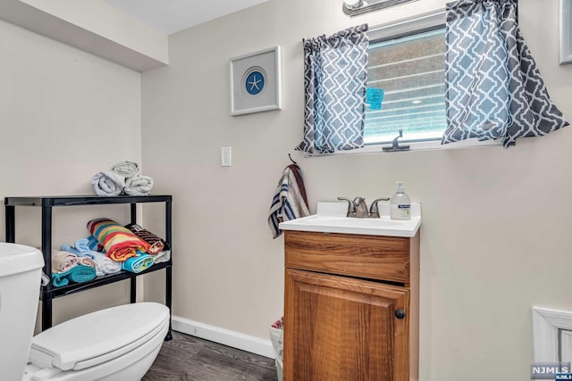 bathroom with vanity, wood-type flooring, and toilet