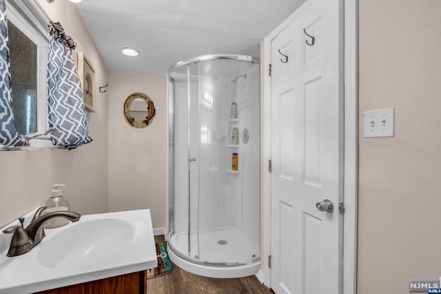 bathroom with vanity, hardwood / wood-style flooring, and walk in shower