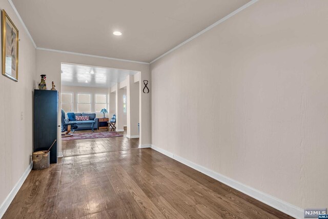 hallway with crown molding and hardwood / wood-style flooring