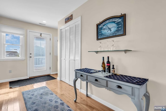 entryway with bar area and wood-type flooring