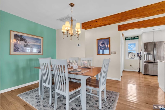 dining room featuring beam ceiling, light wood-type flooring, and an inviting chandelier