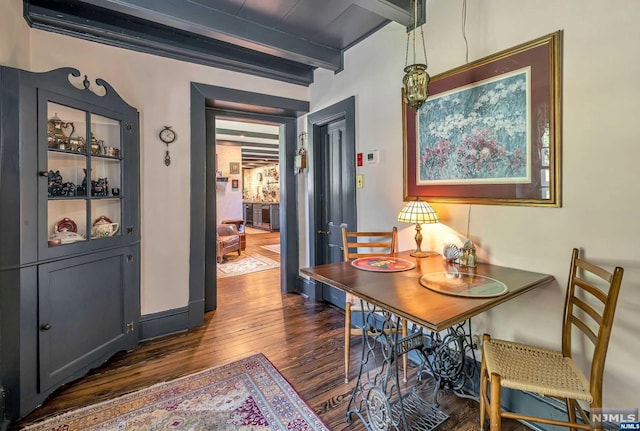 dining room with beamed ceiling and dark wood-type flooring