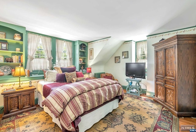 bedroom featuring light hardwood / wood-style floors and vaulted ceiling