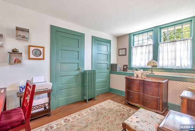 interior space featuring radiator heating unit and hardwood / wood-style floors