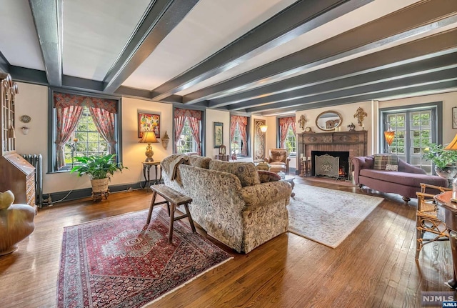 living room with beamed ceiling, hardwood / wood-style flooring, and a fireplace