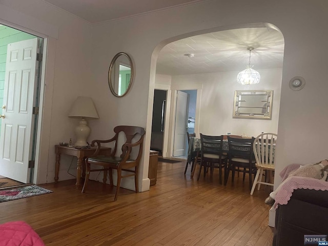 interior space featuring hardwood / wood-style floors, ornamental molding, and a chandelier