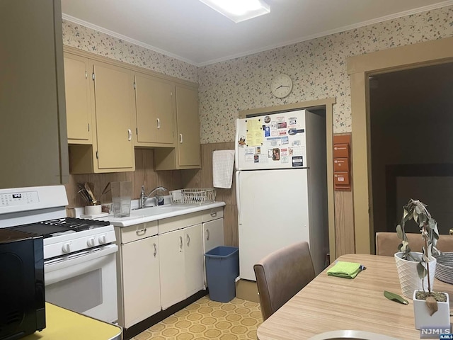 kitchen with cream cabinets, white appliances, crown molding, and sink