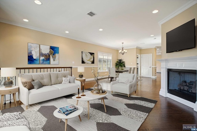 living room featuring a chandelier, hardwood / wood-style flooring, and ornamental molding