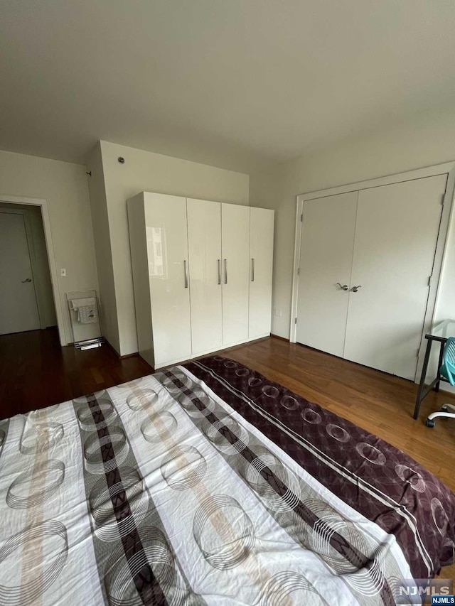 unfurnished bedroom with dark hardwood / wood-style flooring and a closet