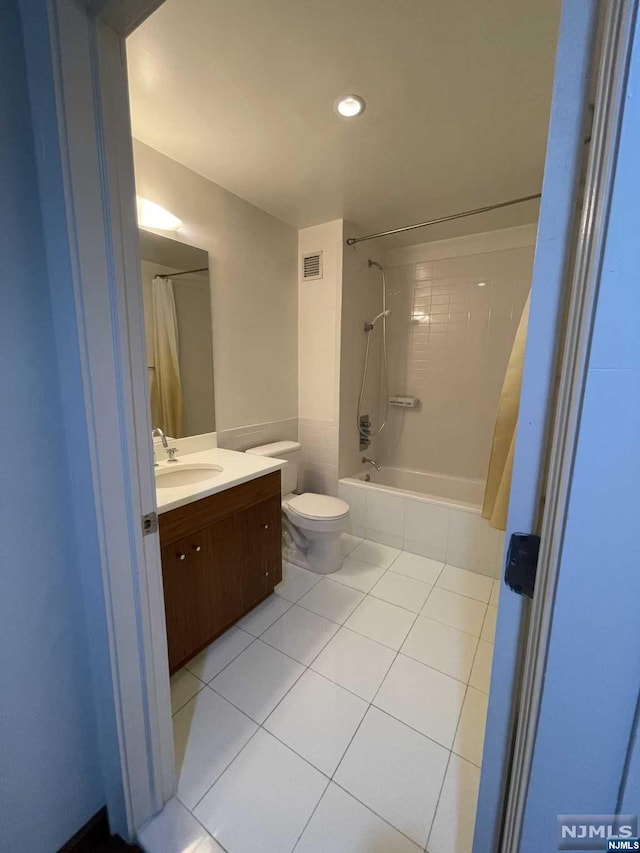 full bathroom featuring tile patterned flooring, vanity, toilet, and shower / tub combo with curtain