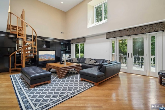 living room with a wealth of natural light, french doors, and a towering ceiling