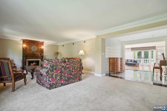 carpeted living room with a large fireplace, ornamental molding, and french doors