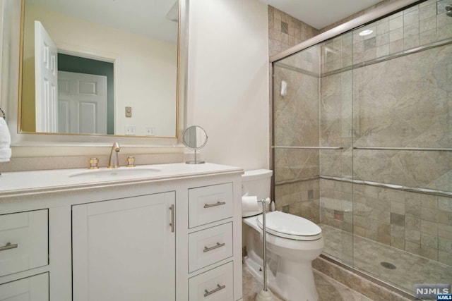 bathroom with tile patterned floors, vanity, toilet, and walk in shower