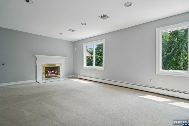 unfurnished living room featuring light colored carpet and a baseboard heating unit