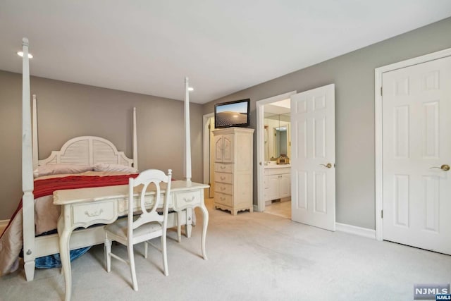 bedroom with ensuite bath and light carpet