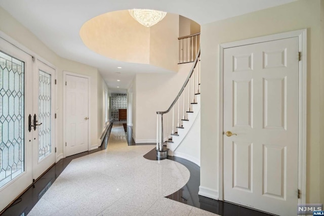 entrance foyer featuring a chandelier and french doors