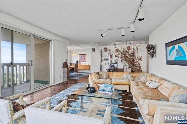 living room featuring a textured ceiling and track lighting