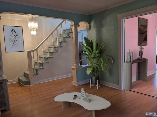 entryway with a chandelier, hardwood / wood-style floors, and crown molding